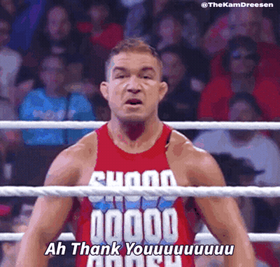 A Wrestler In A Red Tank Top Says " Ah Thank You " In Front Of A Crowd GIF