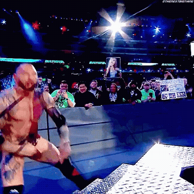 A Wrestler In A Ring With A Sign That Says Batista GIF