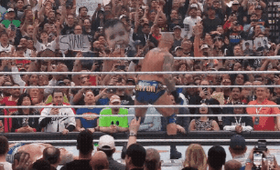 A Wrestler In A Ring With A Sign That Says Shine GIF
