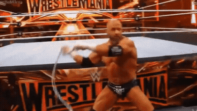 A Wrestler In A Ring With A Sign That Says Wrestlemania GIF