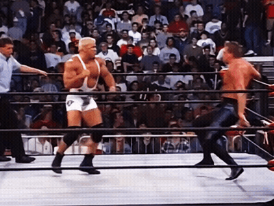 A Wrestler In A White Singlet With The Letter T On It GIF