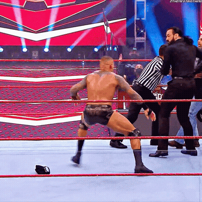 A Wrestler In A Wrestling Ring With A Referee Behind Him And The Word Ethenext Thing On The Bottom Right GIF