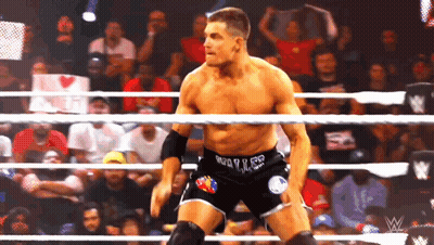 A Wrestler In A Wrestling Ring With A Sign In The Background That Says ' I Love You ' GIF
