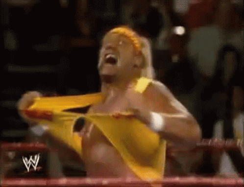 A Wrestler In A Yellow Shirt Is Screaming In A Ring . GIF