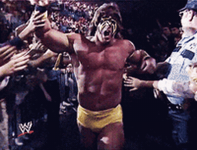 A Wrestler In A Yellow Shorts Is Surrounded By Fans GIF