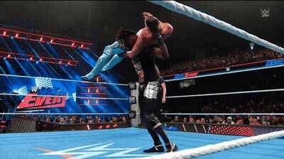 A Wrestler Is Being Lifted In The Air By Another Wrestler During A Match GIF