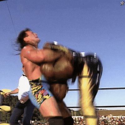 A Wrestler Is Being Lifted Up By Another Wrestler In A Ring GIF