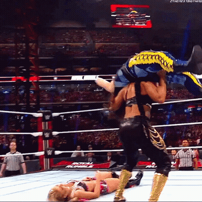 A Wrestler Is Carrying Another Wrestler In A Wrestling Ring That Says Royal Rumble On The Bottom GIF