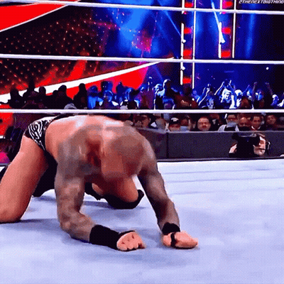 A Wrestler Is Crawling On The Ground In Front Of A Crowd With The Hashtag #Thenextbig Thing GIF