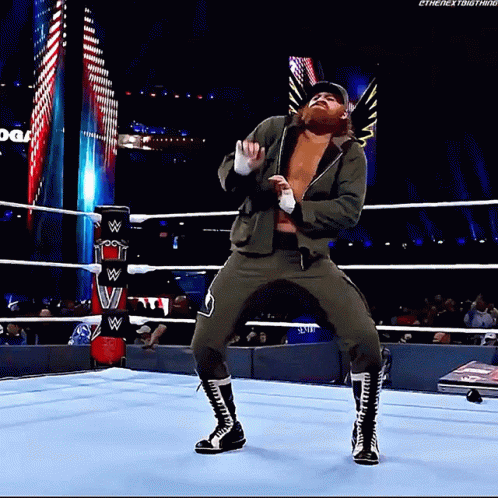 A Wrestler Is Dancing In A Wrestling Ring During A Show . GIF