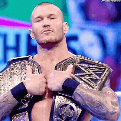 A Wrestler Is Giving A Thumbs Up While Wearing A Championship Belt GIF
