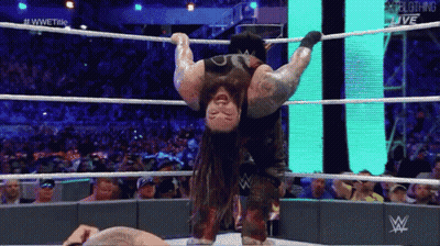 A Wrestler Is Hanging Upside Down In The Ring GIF