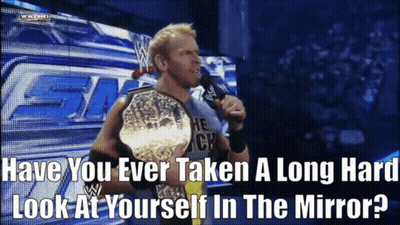 A Wrestler Is Holding A Championship Belt And Talking Into A Microphone GIF