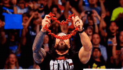 A Wrestler Is Holding A Red Chain Around His Neck . GIF
