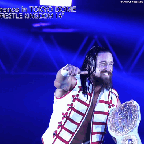 A Wrestler Is Holding A World Heavyweight Championship While Pointing At The Camera GIF