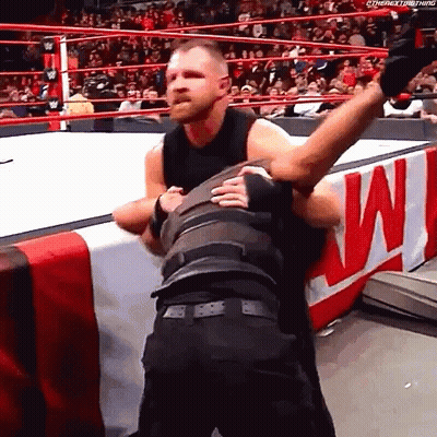 A Wrestler Is Hugging Another Wrestler In A Wrestling Ring During A Match . GIF