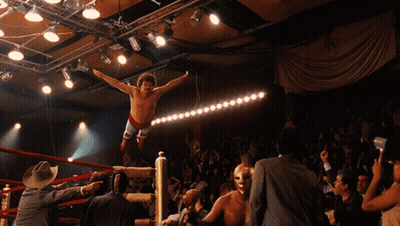 A Wrestler Is Jumping In The Air In A Ring GIF