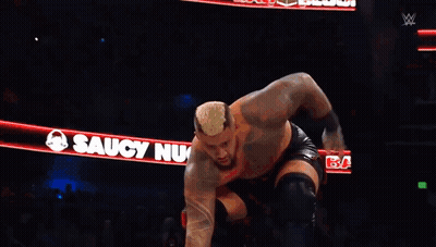 A Wrestler Is Jumping Over Another Wrestler In A Ring GIF