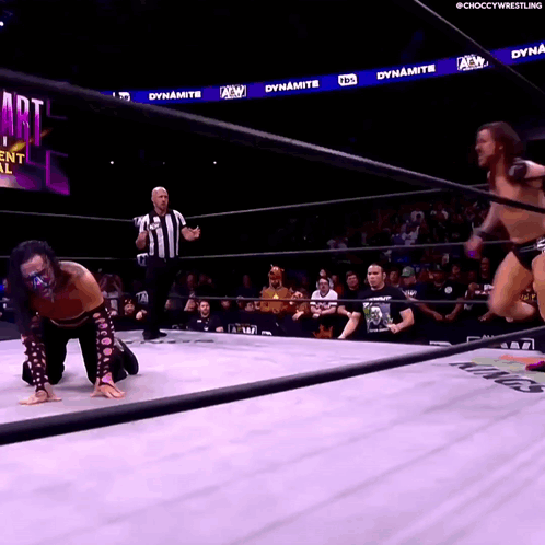 Wrestler Kneeling In Ring While Another Jumps GIF
