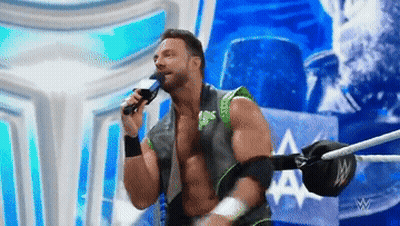 A Wrestler Is Singing Into A Microphone While Standing In A Ring GIF