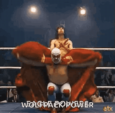 A Wrestler Is Sitting On Another Wrestler 'S Shoulders In A Ring . GIF