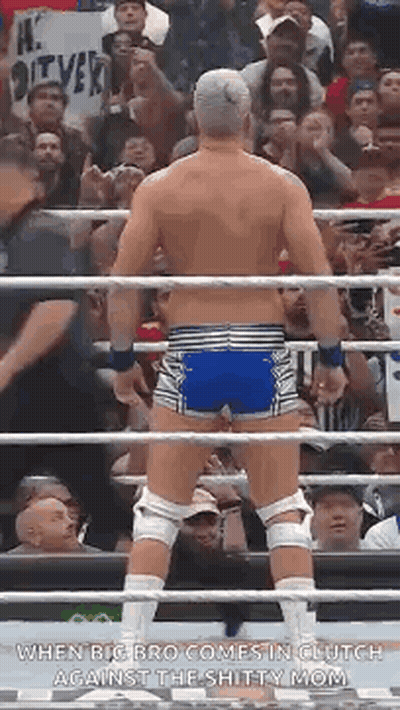 A Wrestler Is Standing In A Ring With His Back To The Camera . GIF