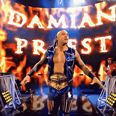 A Wrestler Is Standing In Front Of A Banner That Says Damian Priest On It GIF
