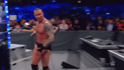 A Wrestler Is Standing In Front Of A Crowd While Wearing Shorts And Boxing Gloves GIF