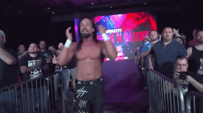 A Wrestler Is Standing In Front Of A Crowd With A Sign That Says ' I 'M A Winner ' GIF