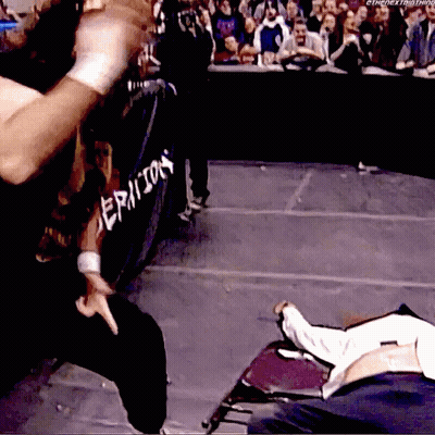 A Wrestler Is Standing In Front Of A Fence That Says Epicon GIF