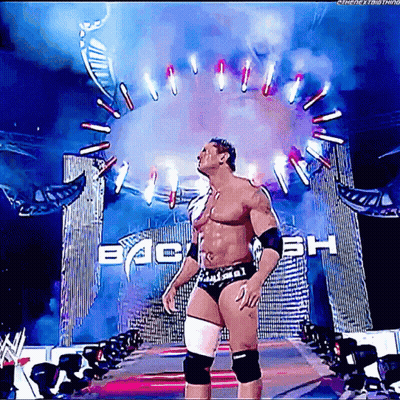 A Wrestler Is Standing In Front Of A Sign That Says Back GIF