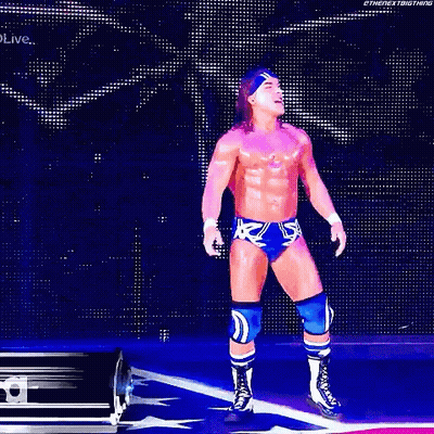 A Wrestler Is Standing In Front Of A Sign That Says Chad Gable GIF