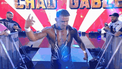 A Wrestler Is Standing In Front Of A Sign That Says Chau Gabu GIF