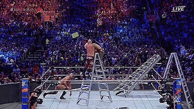 A Wrestler Is Standing On A Ladder In A Wrestling Ring During A Match . GIF