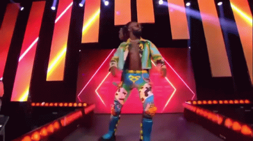 A Wrestler Is Standing On A Stage In Front Of A Crowd . GIF