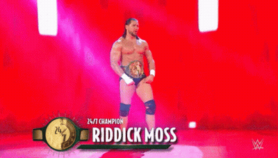 A Wrestler Is Standing On A Stage Wearing A Belt And Knee Pads . GIF