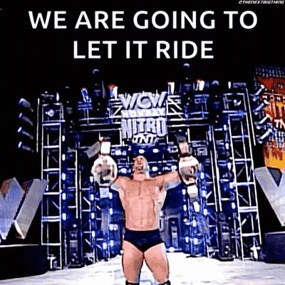 A Wrestler Is Standing On A Stage With His Arms Outstretched And A Sign That Says We Are Going To Let It Ride GIF