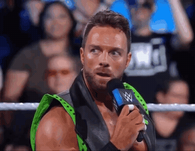 A Wrestler Is Talking Into A Microphone In A Ring . GIF