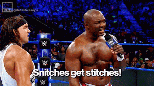 A Wrestler Is Talking Into A Microphone While Another Wrestler Looks On And Says Snitches Get Stitches GIF