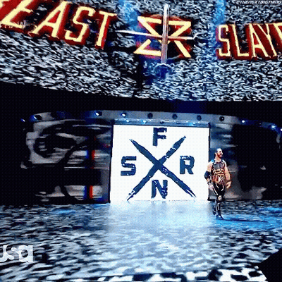 A Wrestler Is Walking Down A Stage With A Large Screen Behind Him That Says East Slay GIF
