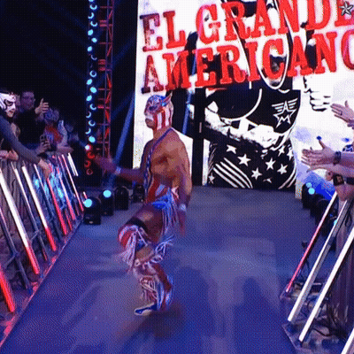 A Wrestler Is Walking Through A Tunnel With A Sign That Says El Grande Americano GIF