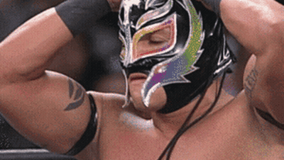A Wrestler Is Wearing A Mask With A Rainbow Design On His Face . GIF