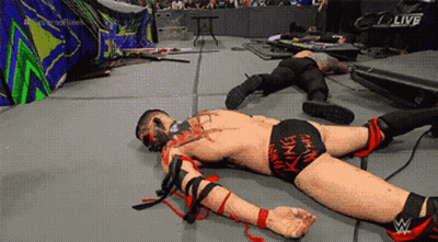 A Wrestler Laying On The Ground With The Word Live On The Screen GIF