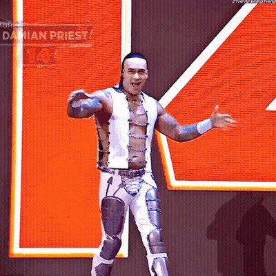 A Wrestler Named Damian Priest Stands In Front Of An Orange Sign GIF
