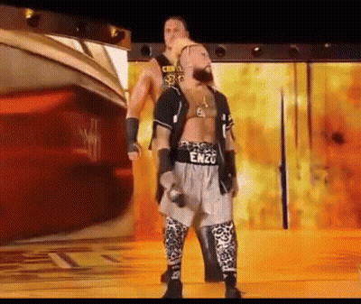 A Wrestler Named Enzo Is Standing Next To Another Wrestler On A Stage GIF