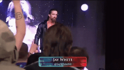 A Wrestler Named Jay White Is Standing In Front Of A Crowd Of People GIF