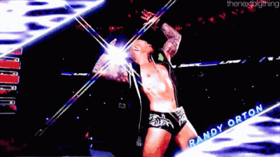 A Wrestler Named Randy Orton Is Standing On A Stage With His Arms Outstretched GIF