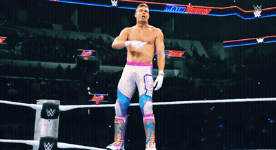 A Wrestler Stands In A Ring With A Sign That Says Main Event GIF