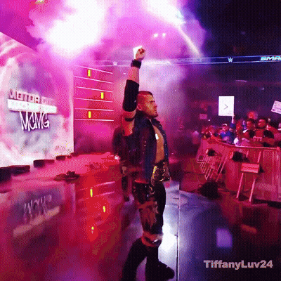 A Wrestler Stands In Front Of A Sign That Says Wwe GIF