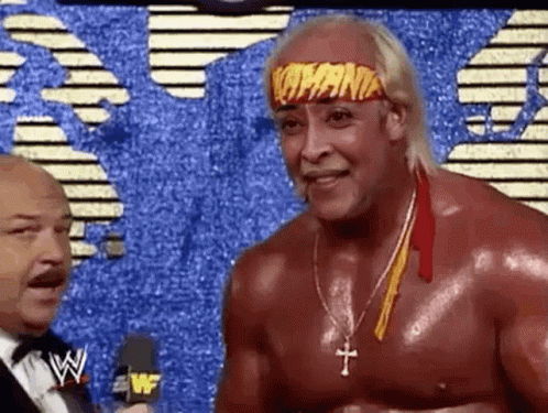 A Wrestler Wearing A Headband With The Word Hogan On It Is Talking To A Man In A Suit . GIF